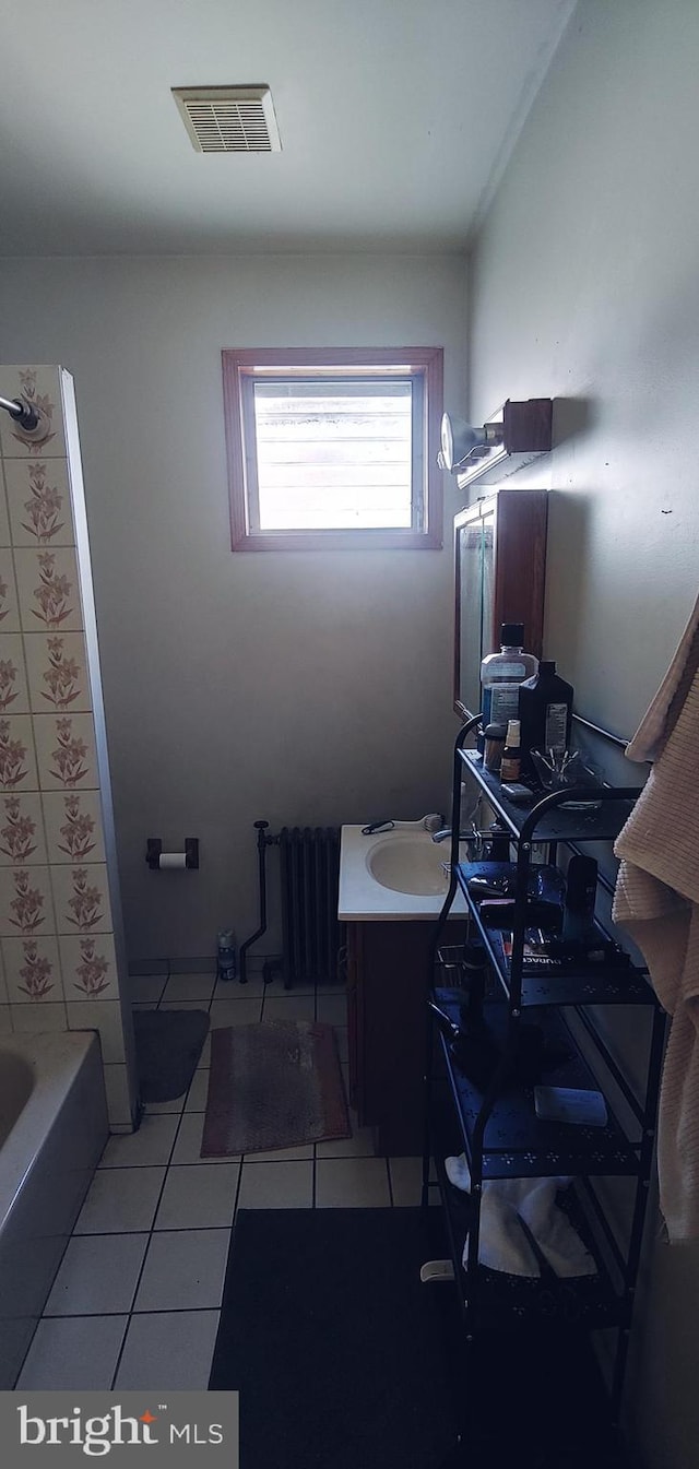 bathroom featuring tile flooring, washtub / shower combination, vanity, and radiator