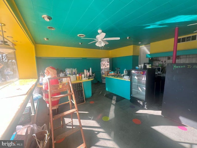 interior space with ceiling fan and concrete flooring