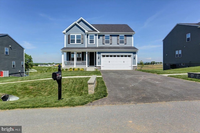 view of front of home featuring covered porch, a garage, and a front lawn