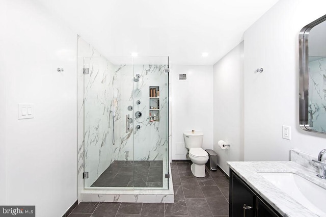 bathroom with a shower with door, vanity, and toilet