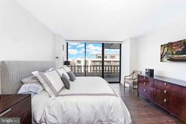 bedroom with dark hardwood / wood-style floors, expansive windows, and access to exterior