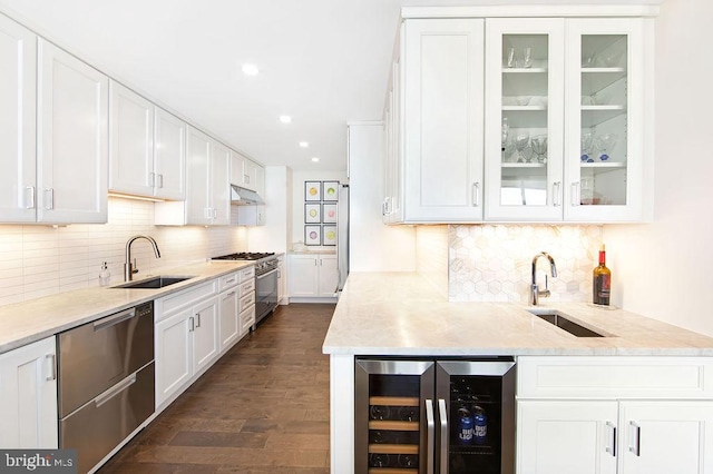 kitchen with white cabinetry, sink, beverage cooler, and stainless steel appliances