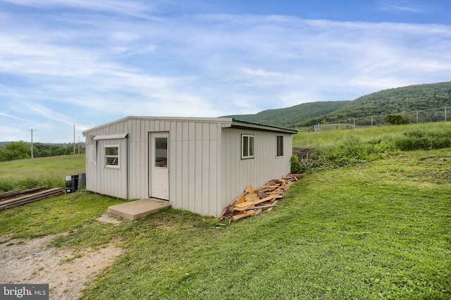 view of shed / structure with a yard, a mountain view, and a rural view