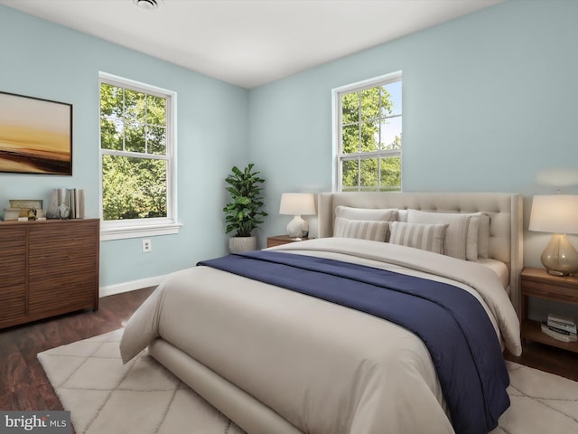 bedroom with multiple windows and hardwood / wood-style flooring