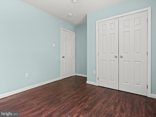 unfurnished bedroom featuring dark hardwood / wood-style flooring and a closet