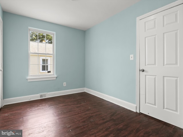 spare room with dark wood-type flooring