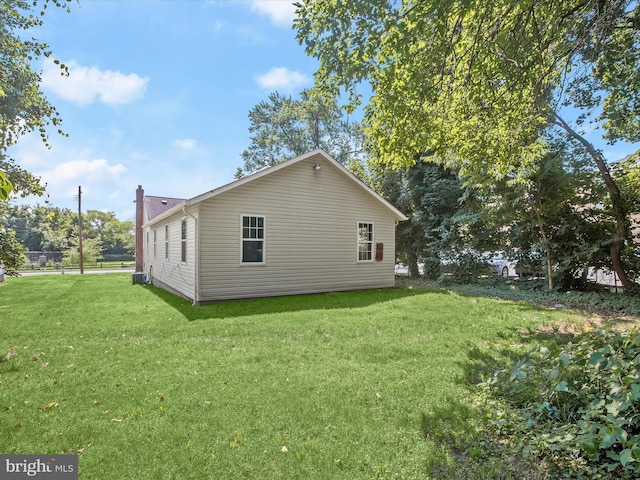 view of home's exterior featuring central AC unit and a yard