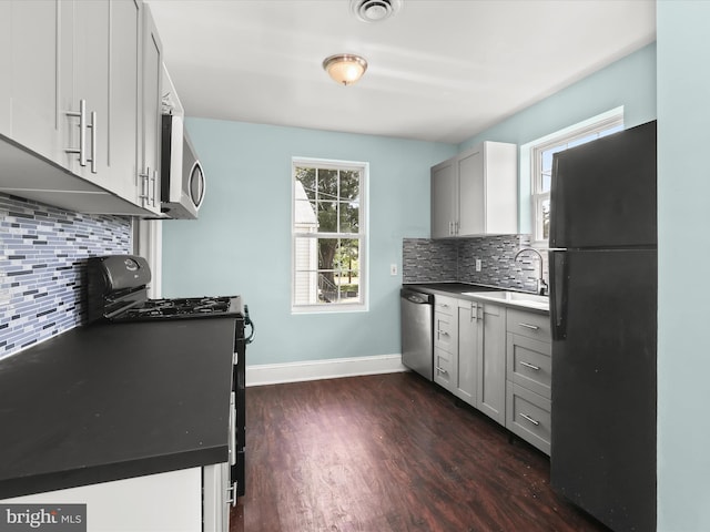 kitchen with black appliances, dark hardwood / wood-style floors, sink, and tasteful backsplash