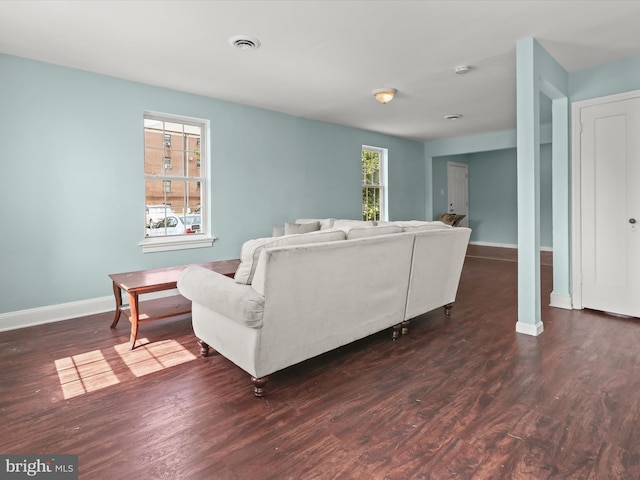 living room featuring dark hardwood / wood-style floors and a healthy amount of sunlight