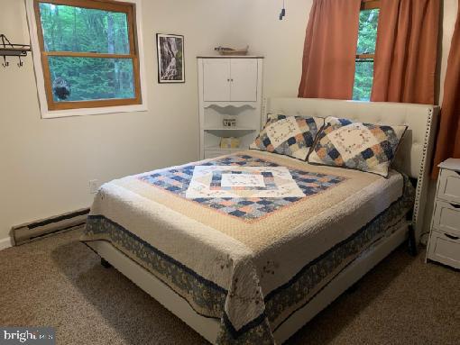 carpeted bedroom featuring a baseboard radiator