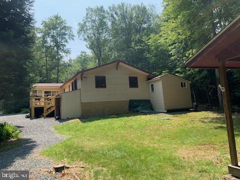 view of side of home with a shed and a lawn