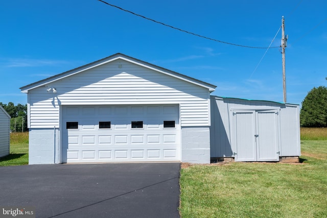 exterior space featuring a yard, a storage unit, and a garage