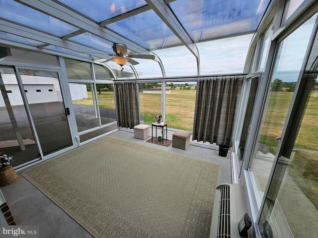 unfurnished sunroom featuring ceiling fan