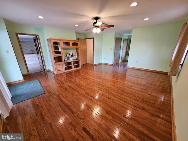 unfurnished living room featuring ceiling fan and hardwood / wood-style flooring