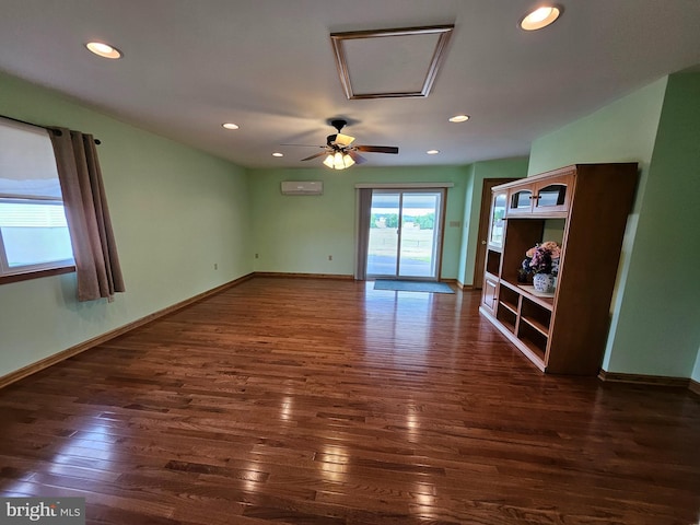 empty room featuring ceiling fan, dark hardwood / wood-style floors, and a wall unit AC