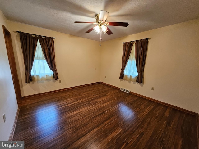 spare room featuring dark hardwood / wood-style flooring, a textured ceiling, and ceiling fan