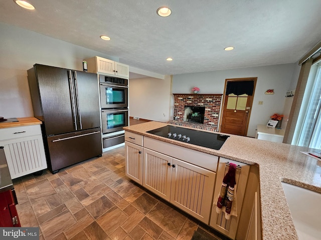 kitchen with sink, a textured ceiling, and black appliances