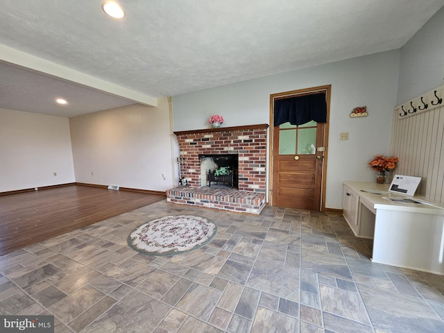 living room featuring a brick fireplace and a textured ceiling