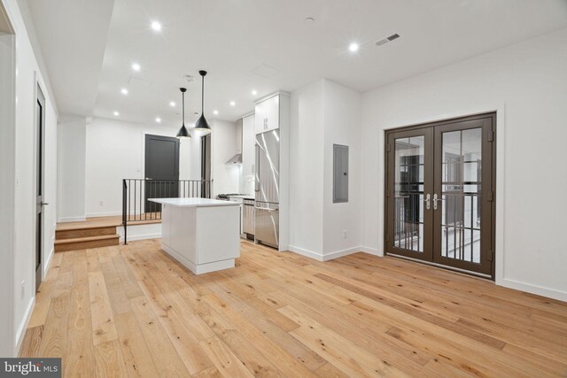 kitchen with french doors, light hardwood / wood-style floors, pendant lighting, and a kitchen island