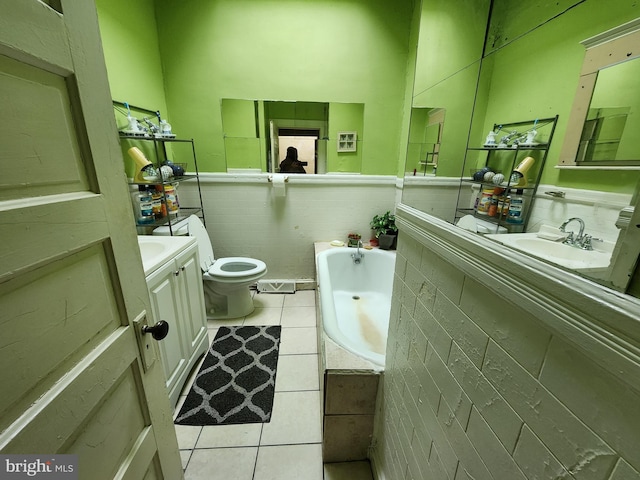 bathroom with tile floors, a washtub, toilet, and vanity