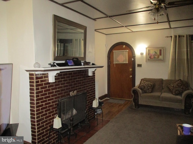 living room with ceiling fan, dark hardwood / wood-style floors, and a fireplace