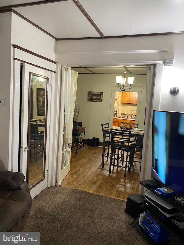 dining space featuring a chandelier, french doors, hardwood / wood-style flooring, and ornamental molding