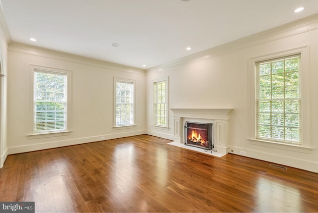 unfurnished living room featuring hardwood / wood-style floors and crown molding