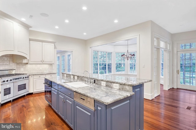 kitchen featuring dark hardwood / wood-style flooring, white cabinetry, sink, and appliances with stainless steel finishes