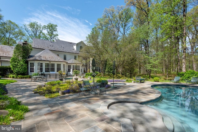 view of pool with a hot tub and a patio area