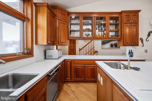 kitchen featuring light hardwood / wood-style floors, sink, lofted ceiling, and dishwasher