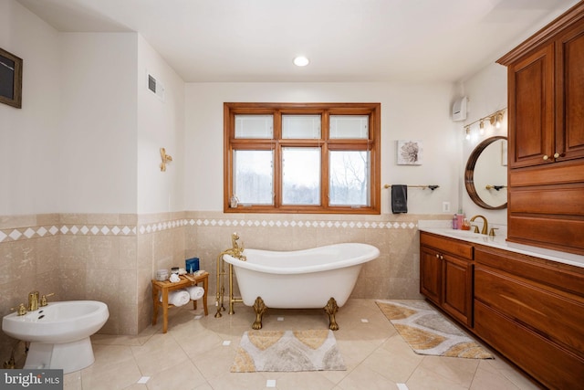 bathroom featuring tile walls, a bidet, tile flooring, a bathtub, and vanity