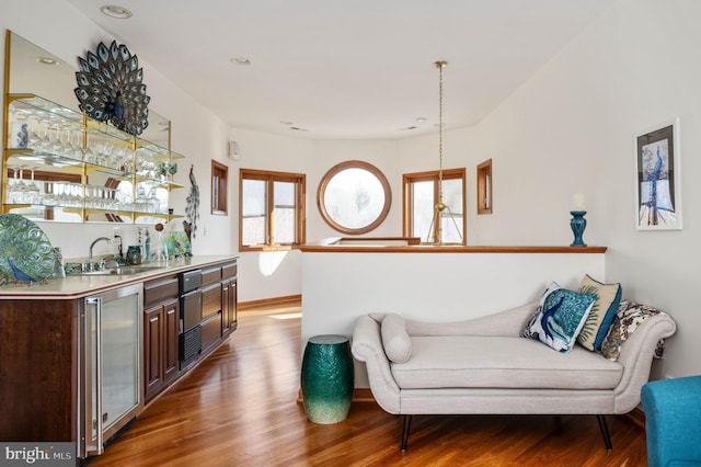 interior space featuring wine cooler, sink, and wood-type flooring