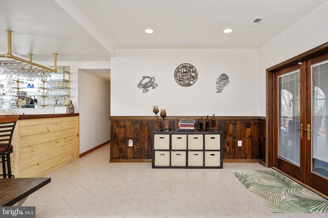 interior space featuring french doors, light tile flooring, and bar