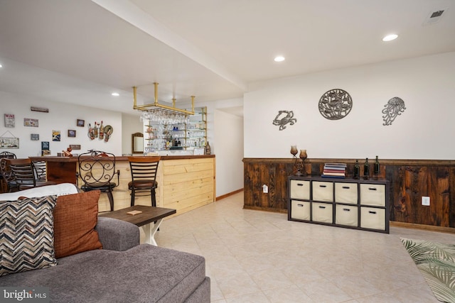 living room featuring indoor bar and light tile floors