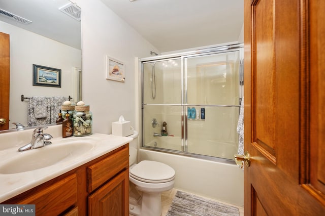 full bathroom featuring tile floors, shower / bath combination with glass door, oversized vanity, and toilet