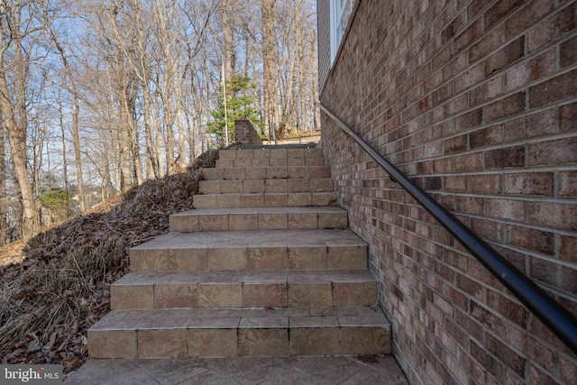 stairs featuring brick wall