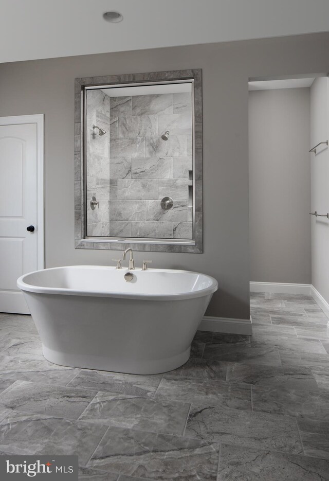 bathroom with a soaking tub, baseboards, a tile shower, and marble finish floor