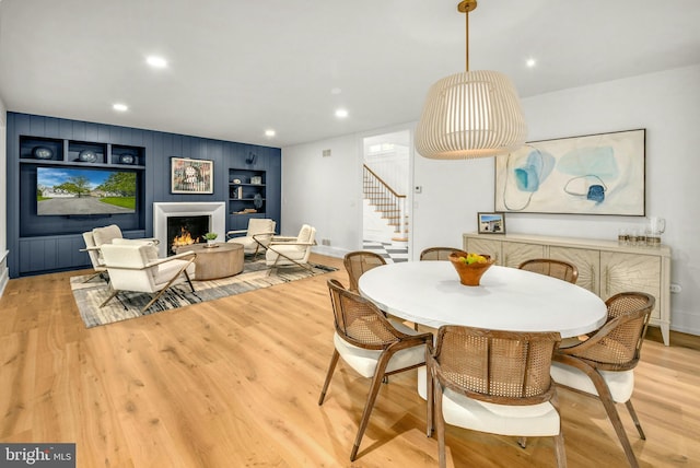 dining space with built in features and light hardwood / wood-style flooring