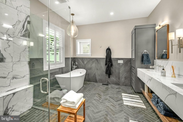 bathroom with dual sinks, tile flooring, independent shower and bath, tile walls, and large vanity