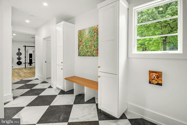 mudroom with dark tile flooring and plenty of natural light