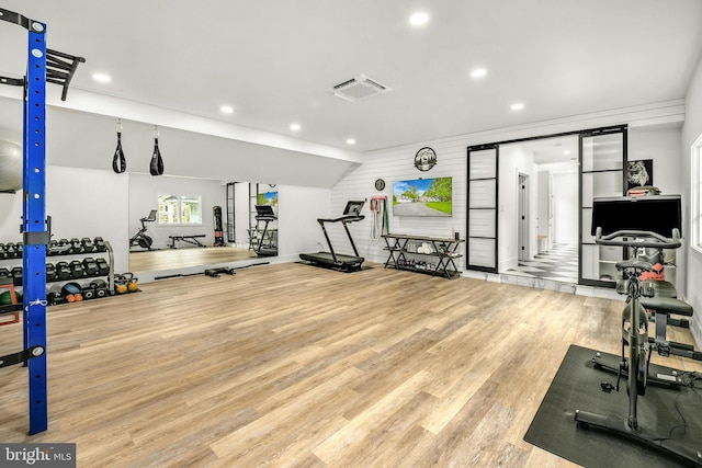 workout area with light hardwood / wood-style flooring