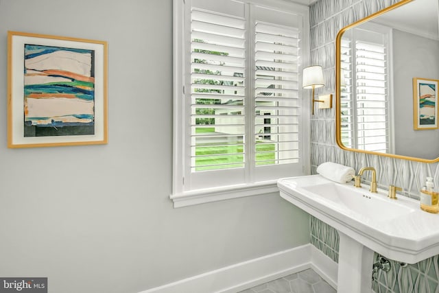 bathroom with tile flooring, a healthy amount of sunlight, and crown molding