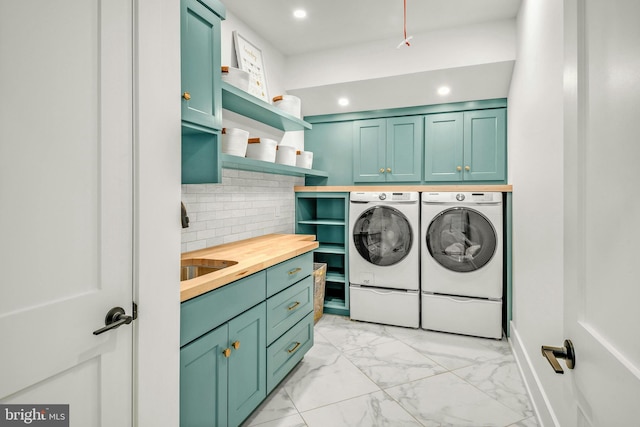 washroom featuring cabinets, sink, light tile flooring, and washing machine and clothes dryer