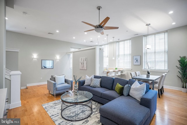 living room with light wood-type flooring and ceiling fan