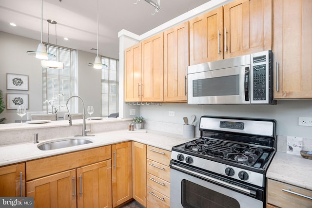 kitchen with decorative light fixtures, light brown cabinets, sink, and appliances with stainless steel finishes