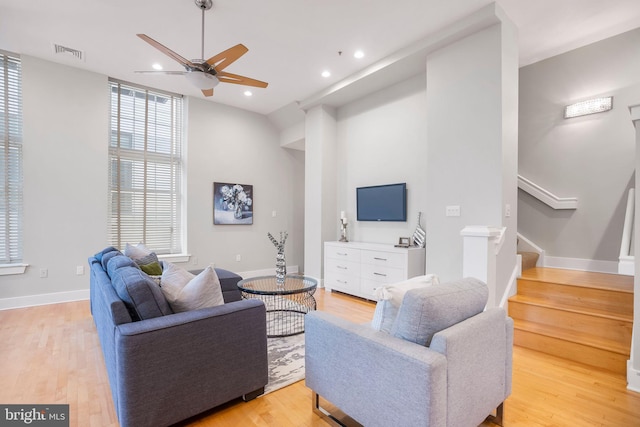 living room featuring light wood-type flooring, vaulted ceiling, and ceiling fan