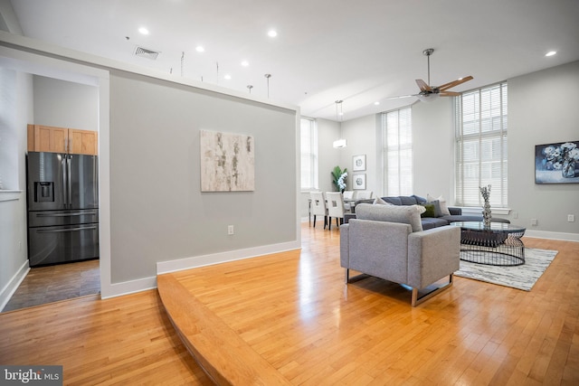 living room with ceiling fan and light hardwood / wood-style flooring