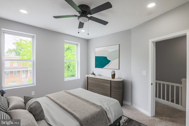 carpeted bedroom featuring multiple windows and ceiling fan