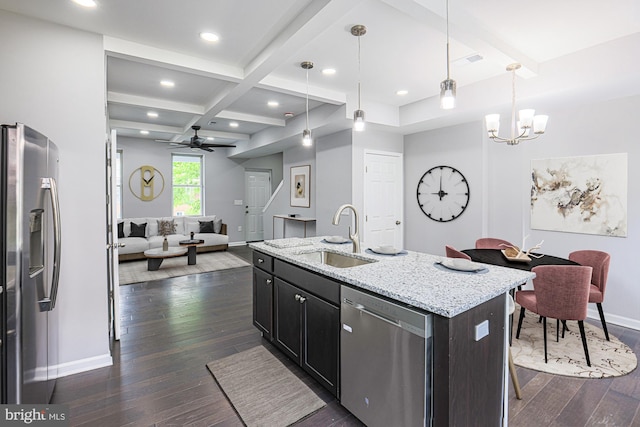 kitchen featuring ceiling fan with notable chandelier, an island with sink, stainless steel appliances, and decorative light fixtures