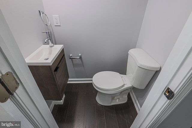 bathroom with hardwood / wood-style floors, vanity, and toilet